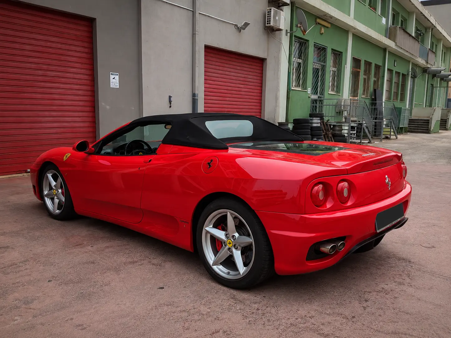 Ferrari rossa davanti all'officina Pitlane