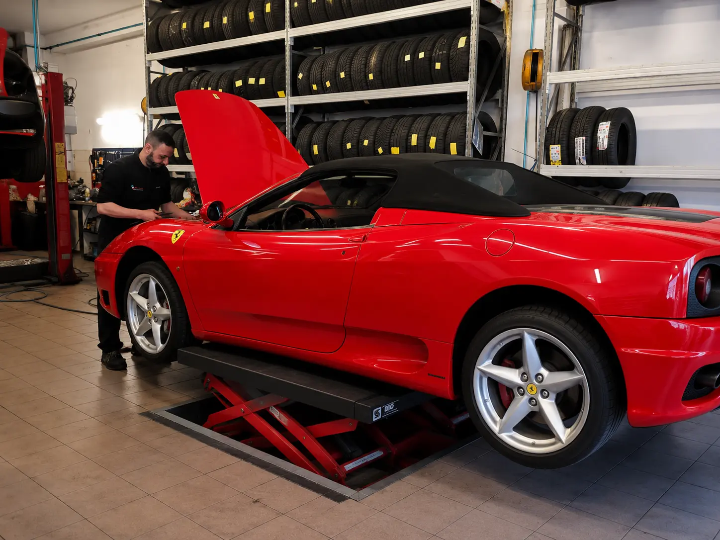 Ferrari rossa sul ponte con cofano aperto