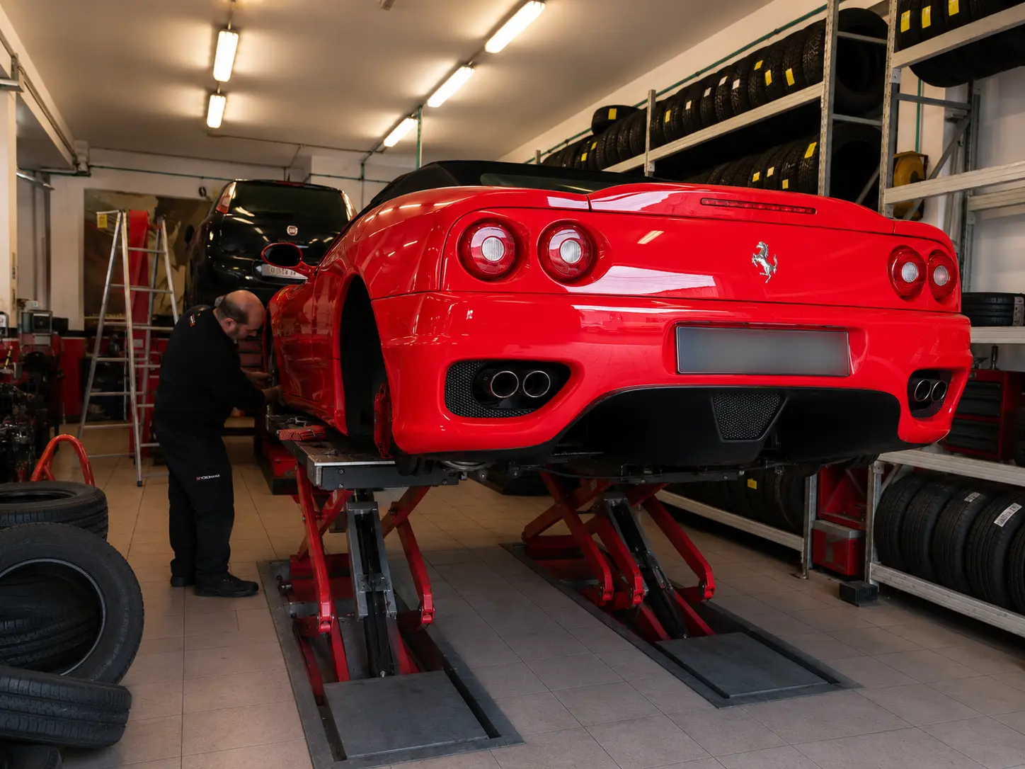 Vista posteriore di una Ferrari rossa sollevata sul ponte